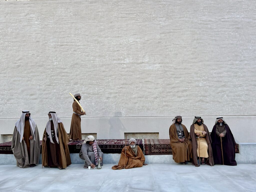 UAE culture in Abu Dhabi local clothing men sitting down in traditional gowns