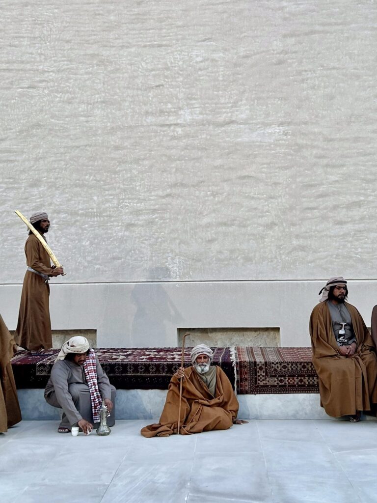 UAE culture in Abu Dhabi local clothing men sitting down in traditional gowns